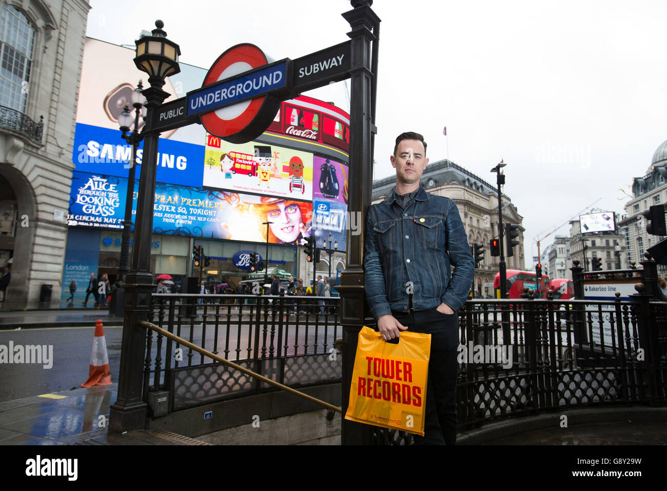 Colin Hanks holding a Tower Records bag at Piccadilly Circus in London, the star of The Good Guys and Fargo, makes his directorial debut with All Things Must Pass, a film that tells the story of Tower Records and features Sir Elton, Foo Fighters frontman Dave Grohl and singer Bruce Springsteen. Stock Photo