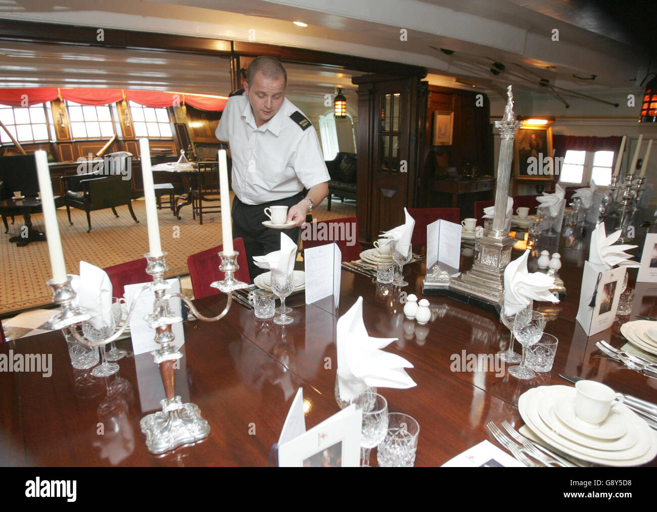 Steward Nick Brier sets the table with a dinner set presented to the