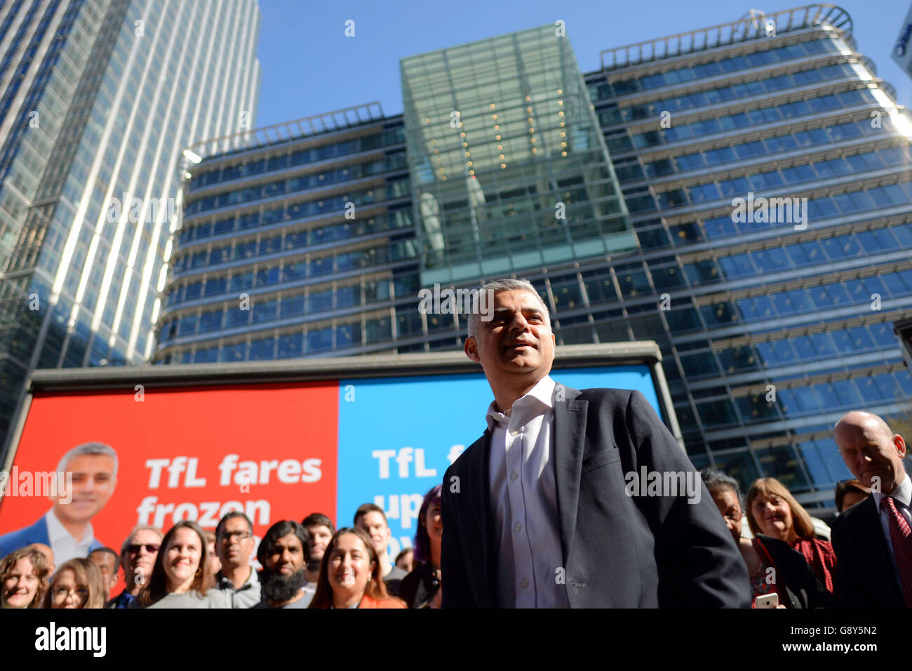 Sadiq Khan, Labour's Candidate for Mayor of London, speaks in front of Labour's four campaign adverts at Montgomery Square in Canary Wharf, London. Stock Photo
