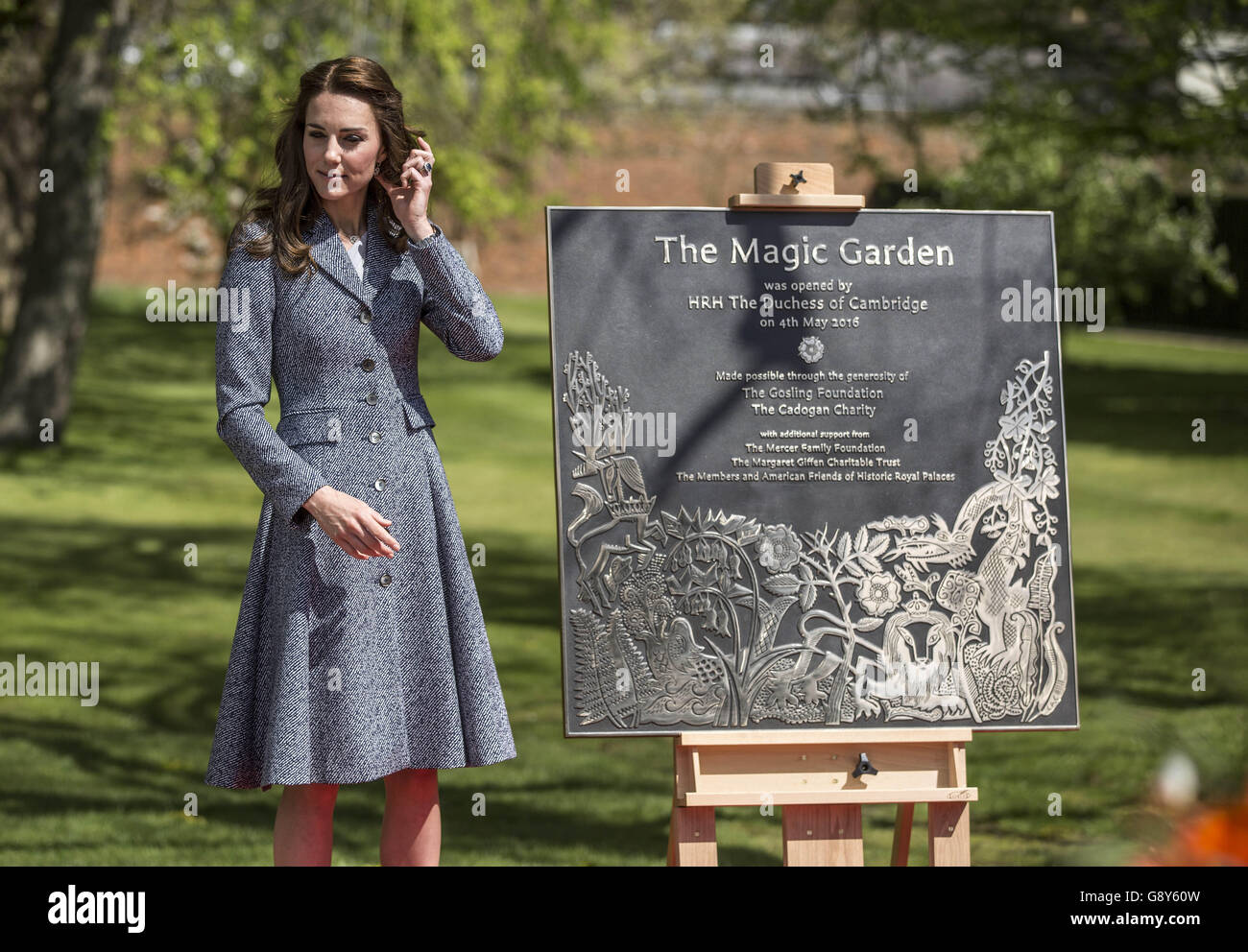 The Duchess of Cambridge with the plaque she unveiled at Hampton Court's recently unveiled Magic Garden, marking the official opening of the palace's new children's play area. Stock Photo