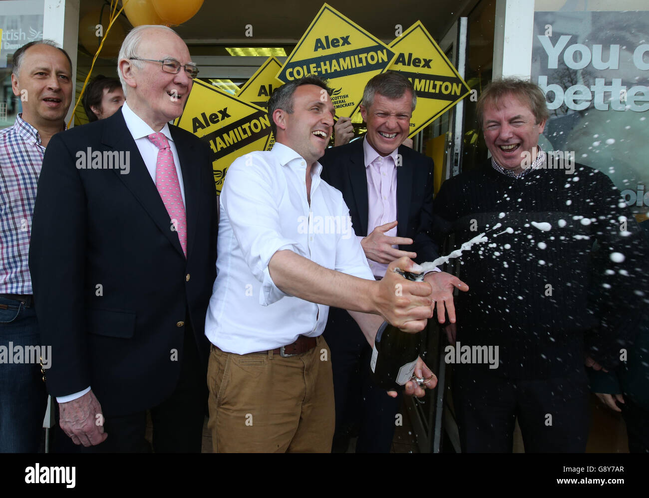 Former Liberal Democrat leader Menzies Campbell (second left), Lib Dem Alex Cole-Hamilton (centre) and Scottish Liberal Democrat leader Wiilie Rennie (second right), as they celebrate in Edinburgh, after Rennie and Cole-Hamilton both won their seats in the Scottish parliamentary elections. Stock Photo