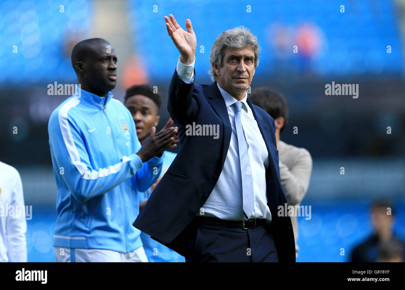 Manchester City manager Manuel Pellegrini salutes the fans after the game with Yaya Toure during the Barclays Premier League match at the Etihad Stadium, Manchester. Stock Photo