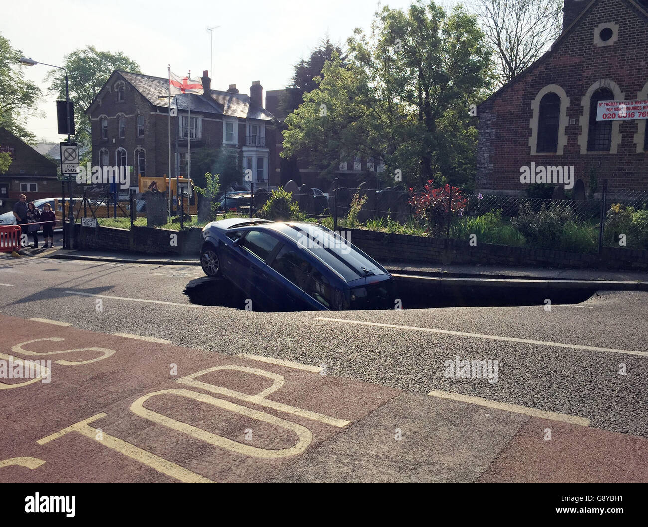 A car which has partially disappeared down a sinkhole in Woodland Terrace in Greenwich, south-east London. Stock Photo