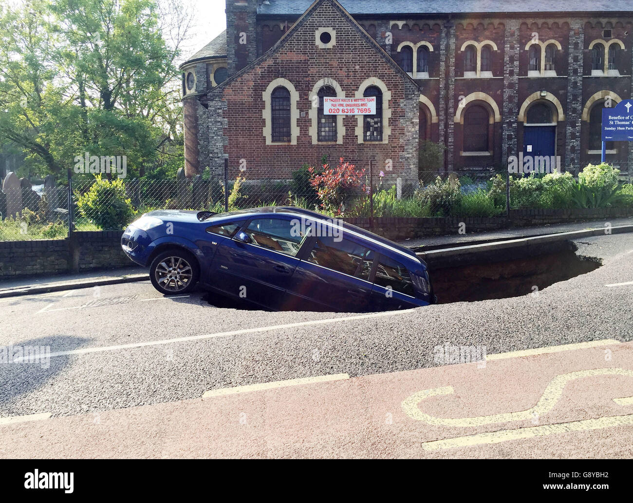 A car which has partially disappeared down a sinkhole in Woodland Terrace in Greenwich, south-east London. Stock Photo