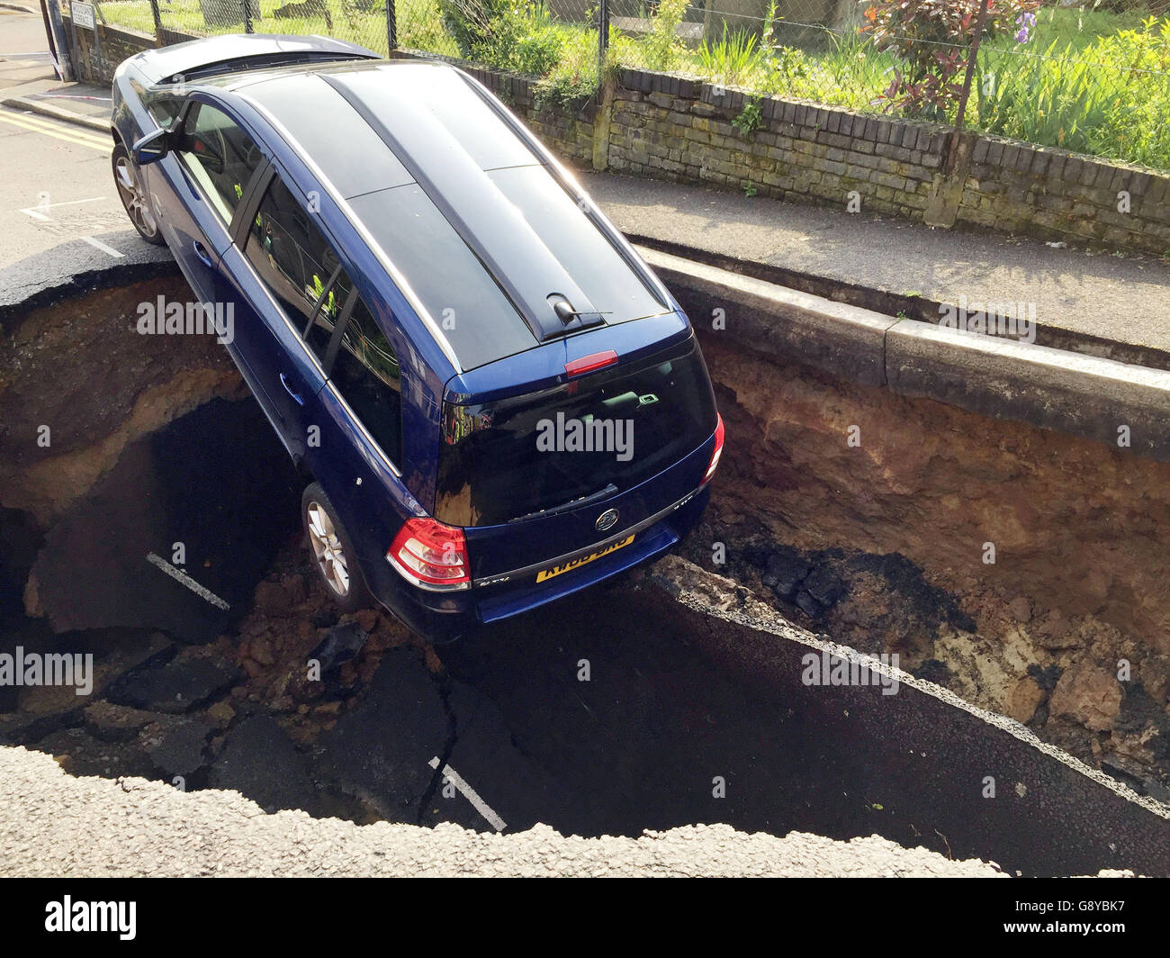 A car which has partially disappeared down a sinkhole in Woodland Terrace in Greenwich, south-east London. Stock Photo