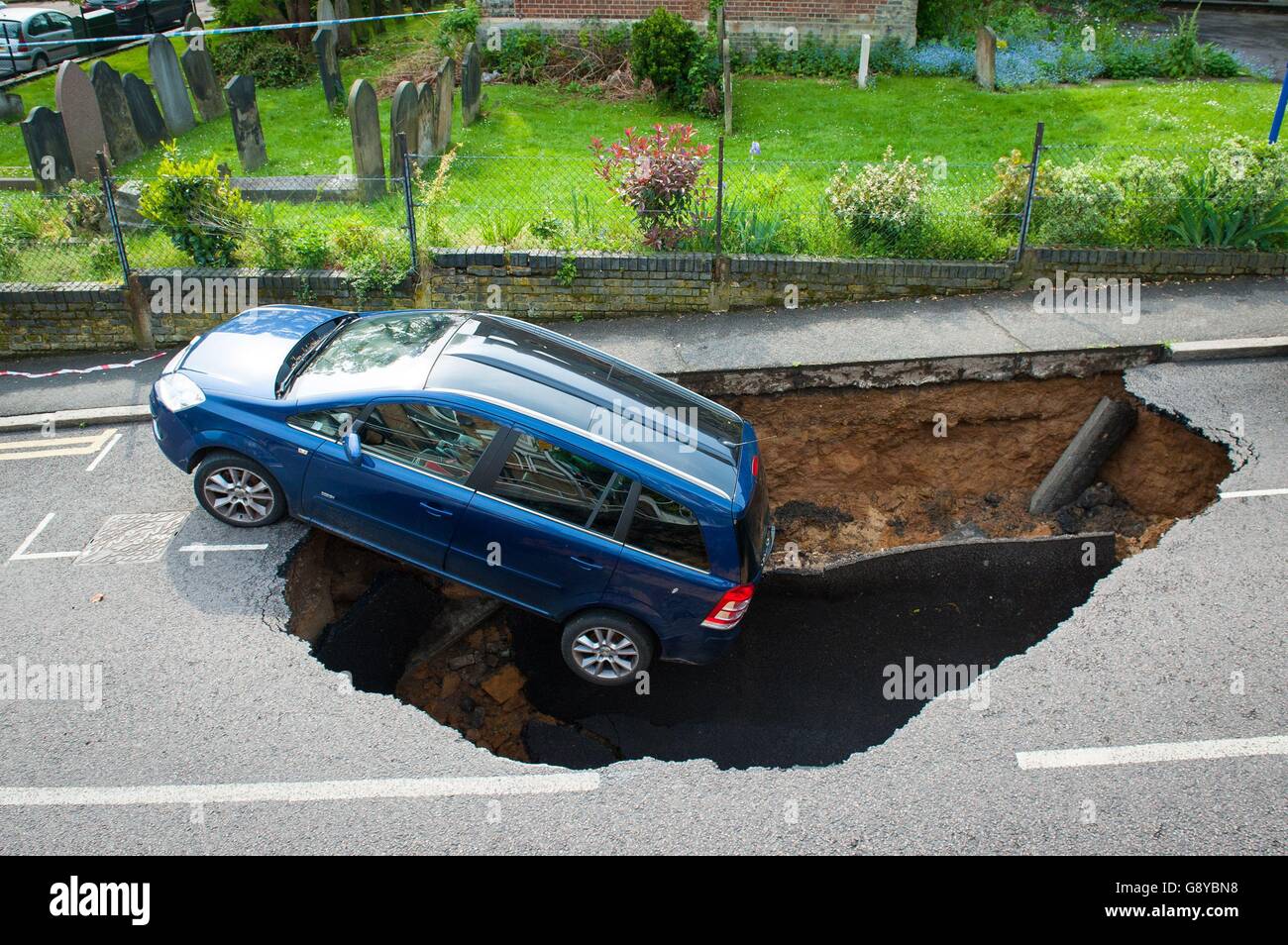 A car which has partially disappeared down a sinkhole in Woodland Terrace in Greenwich, south-east London. Stock Photo