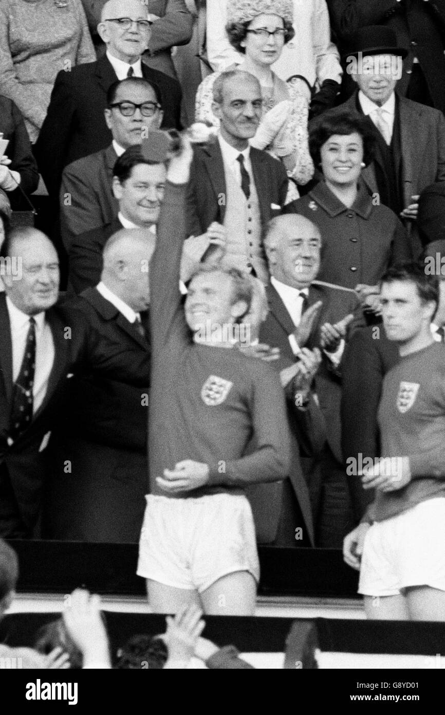 England v West Germany - 1966 World Cup Final - Wembley Stadium. England Captain Bobby Moore holds aloft the Jules Rimet Trophy. He is followed by Geoff Hurst. Stock Photo