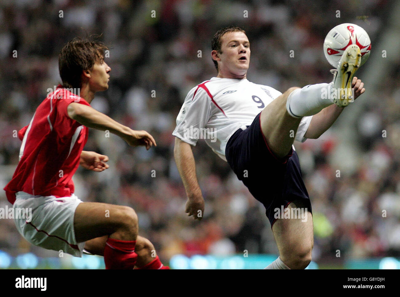 England's Wayne Rooney (R) challenges Poland's Euzebiusz Smolarek during the World Cup qualifying match at Old Trafford, Manchester, Wednesday October 12, 2005. PRESS ASSOCIATION Photo. Photo credit should read: Martin Rickett/PA. Stock Photo