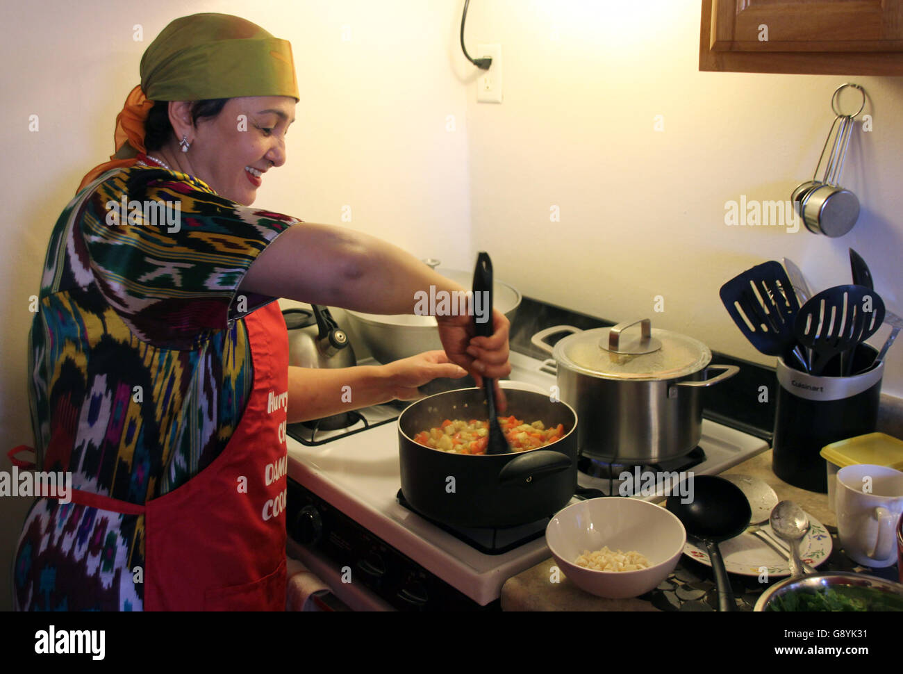 New York, USA. 27th Feb, 2016. Damira Inatullaeva cooks Uzbek Boemjon salad, a type of cooked salad made of eggplants, onions, carrots, dill and corriander, during a cooking class in New York, United States, 27 February 2016. For two months she has worked for the 'League of Kitchens', a cooking school that was praised as the 'UN of kitchens' by the local press. The concept: immigrants introduce a small group of participants to the food and culture of their home country. Photo: Christina Horsten/dpa/Alamy Live News Stock Photo
