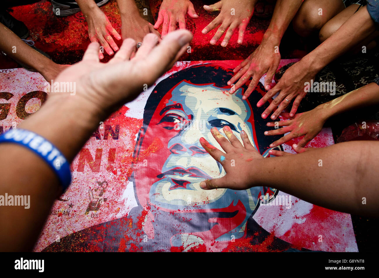 Philippines. 30th June, 2016. Duterte supporters wipe off colored powder off of a tarpauline poster of president Duterte in Mendiola, Manila. Thousands marched to the Mendiola Bridge, near the Malacanang Palace, to call on the newly elected president to implement the changes within the government and to stand as a pro-people administration. The march coincided with Duterte's inauguration as the 16th president of the Republic of the Philippines. Credit:  J Gerard Seguia/ZUMA Wire/Alamy Live News Stock Photo