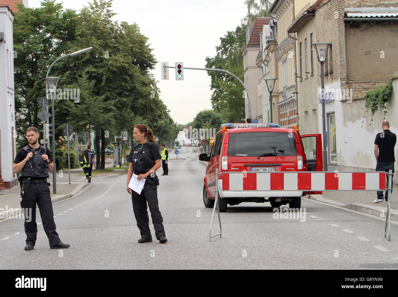 Oranienburg, Germany. 30th June, 2016. Police officers and fire fighters close down a street in Oranienburg, Germany, 30 June 2016. About 12,000 residents had to leave their houses due to the diffusion of a bomb. Photo: Nestor Bachmann/dpa/Alamy Live News Stock Photo