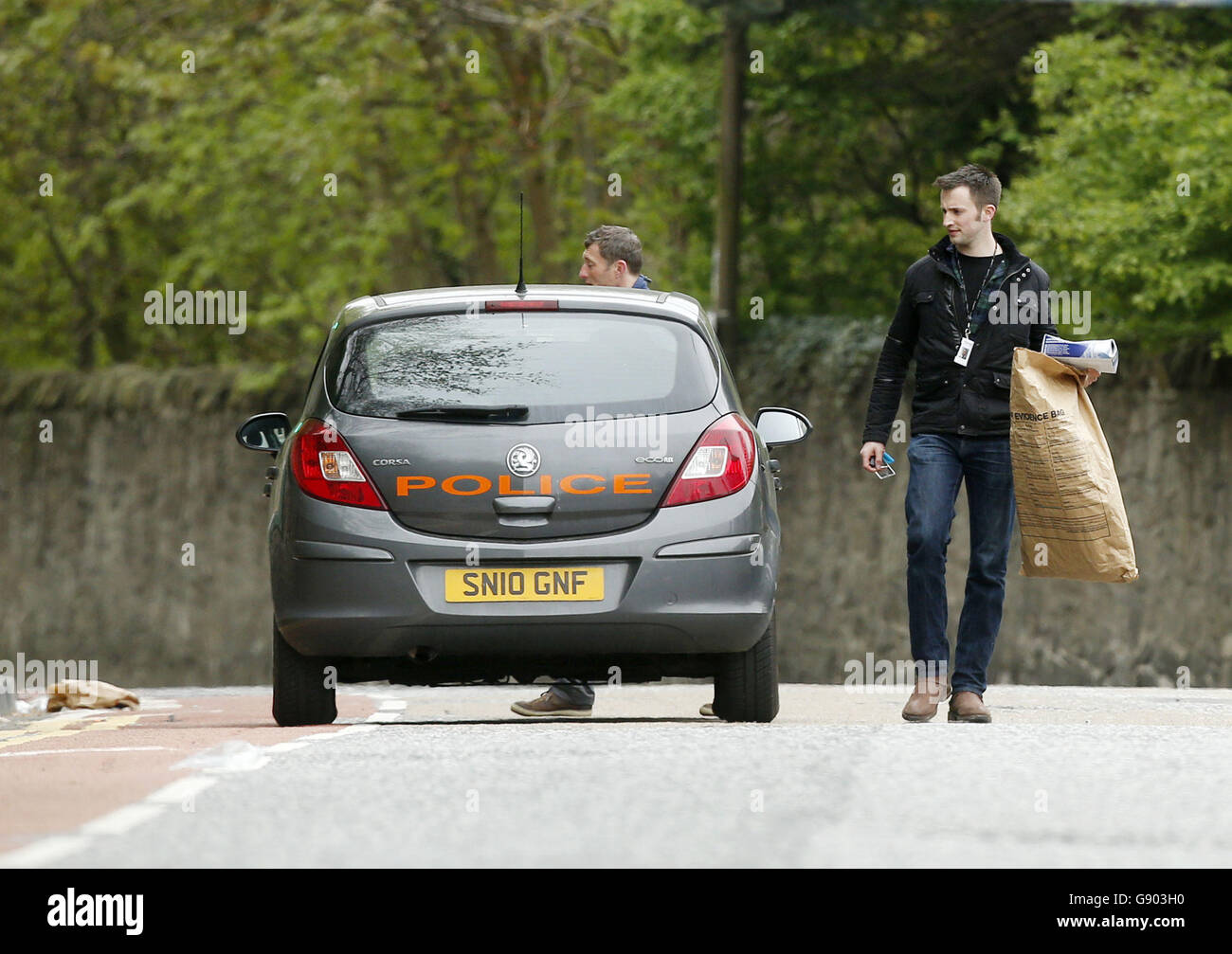 Police officers next to a vehicle (not involved in the incident) at the scene on Old Dalkeith Road in Edinburgh where a woman was knocked down and killed by a car being chased by police. Stock Photo