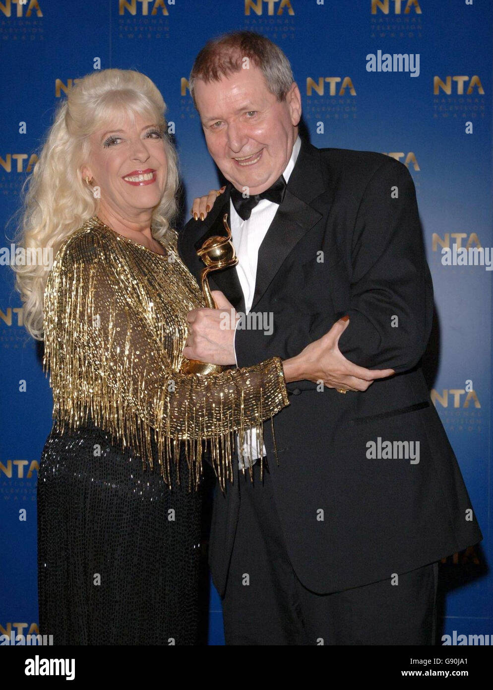 Tony Warren, creator of Coronation Street with the TV Lanmark award he received from actress Julie Goodyear at the National Television Awards 2005 (NTA), at the Royal Albert Hall, central London, Tuesday 25 October 2005. See PA story SHOWBIZ Awards. PRESS ASSOCIATION Photo. Photo credit should read: Ian West/PA Stock Photo