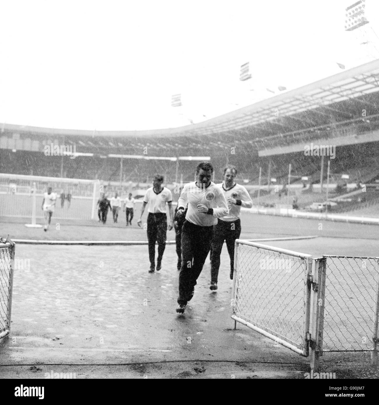 West Germany players run off the pitch as a thunder storm breaks out above. They were training ahead of the World Cup Final against England the next day. Stock Photo