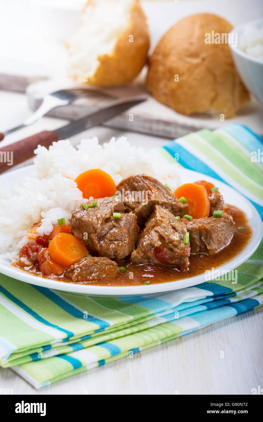 Homemade beef and vegetable casserole served with rice on white plate, comfort food for a cold day Stock Photo