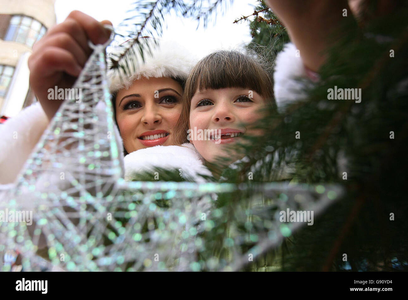 Sky Ireland TV presenter Grainne Seoige with Kate McDonald, 6, hangs a star on the Christmas Tree at Grafton Street, Dublin, Tuesday November 15, 2005. Homeless charity Focus Ireland hopes the tree and its 'Sponsor a Star' campaign will help raise 200,000 Euro to combat homelessness. Standalone photo. PRESS ASSOCIATION Photo. Photo credit should read: Julien Behal/PA. Stock Photo