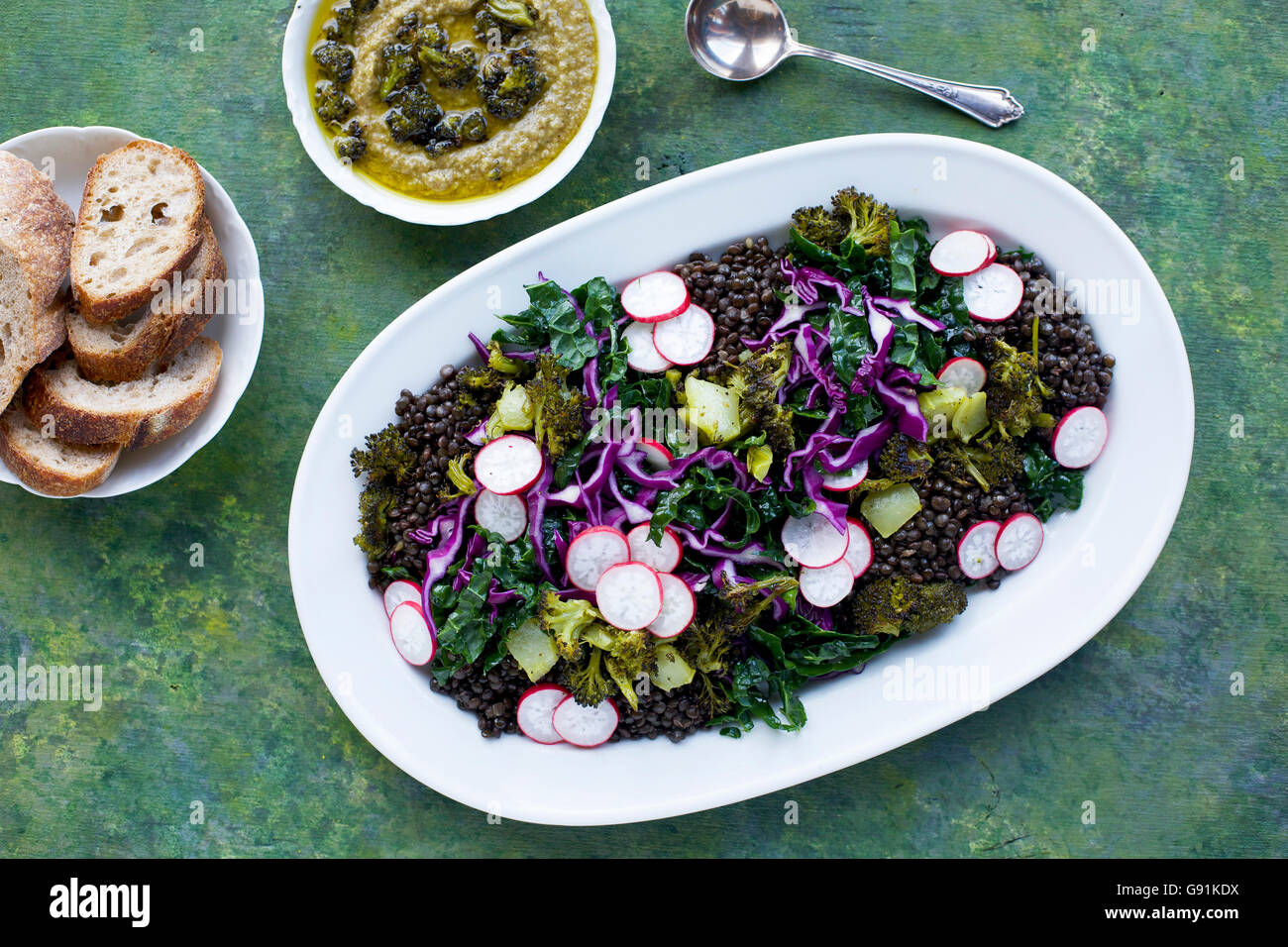 Black Lentil Kale Broccoli Salad with Charred Broccoli Pesto. On a green, yellow and blue