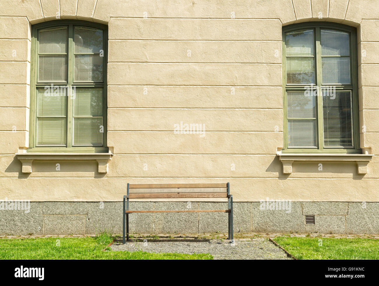 Bench in front of Windows on building with grass Stock Photo - Alamy