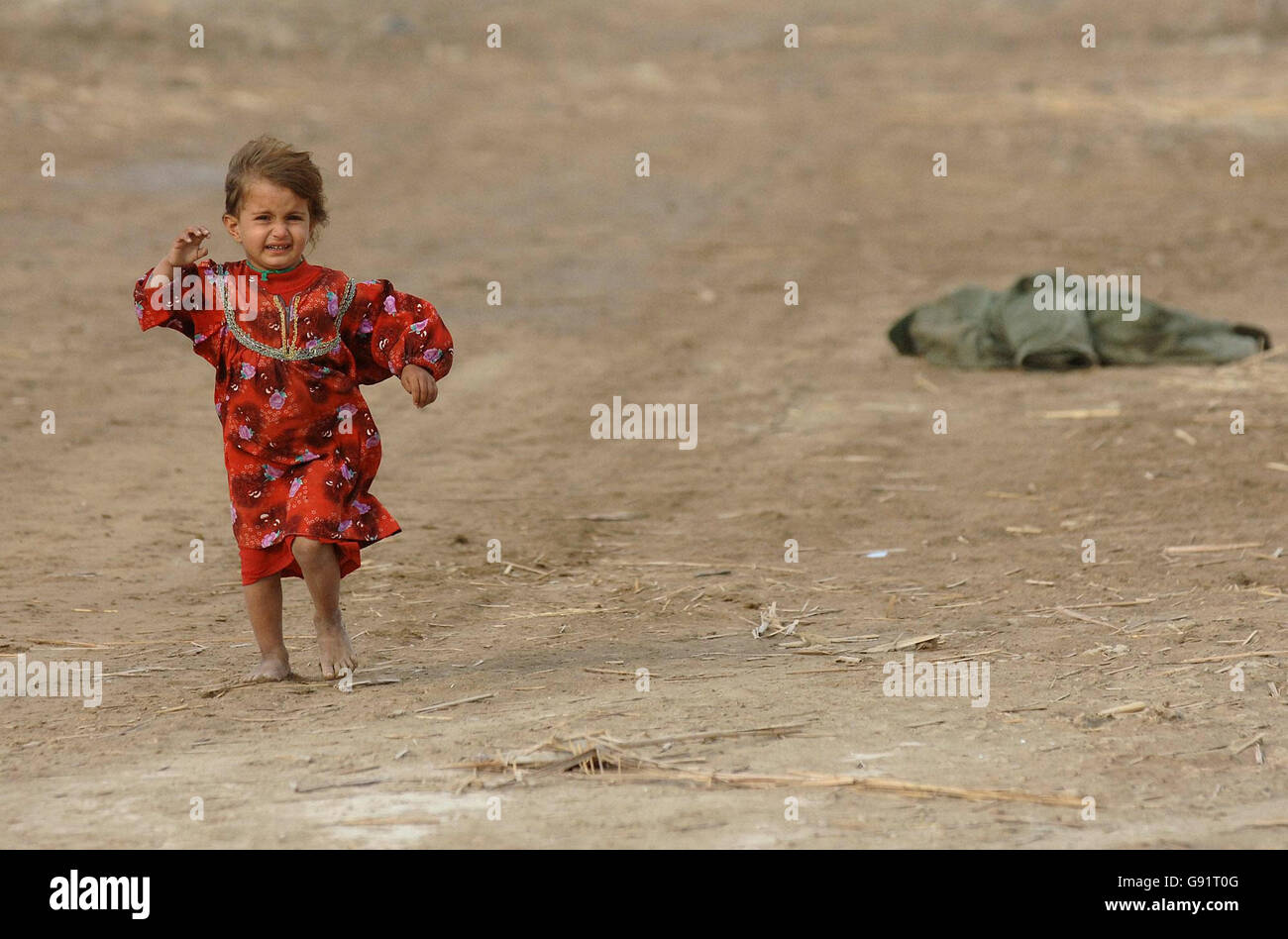 An Iraqi child runs towards her father as 1 Squadron RAF Regiment takes partin a routine patrol in the Marsh Arab region near Basrah. The marshes were drained during the former regime of Saddam Hussein meaning hardship and poverty for many of the Marsh Arabs. Stock Photo