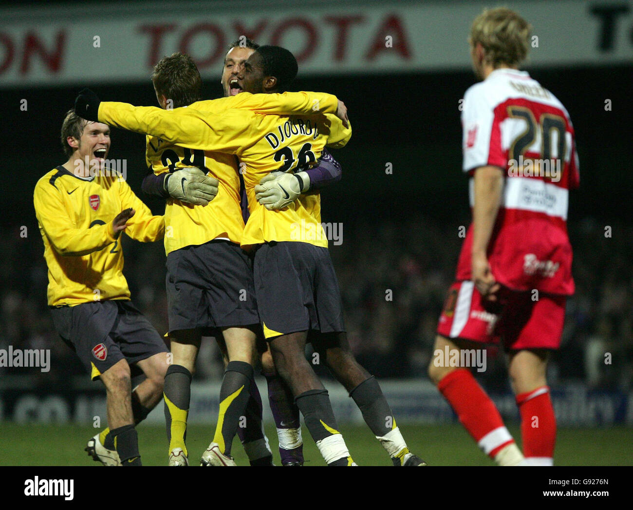Arsenal goalkeeper Manuel Almunia celebrates with team-mates as Doncaster Rovers' Paul Green (R) shows his dejection after he missed vital penalty in the shootout during the Carling Cup quarter-final match at Belle Vue, Doncaster, Wednesday December 21, 2005. PRESS ASSOCIATION Photo. Photo credit should read: Nick Potts/PA. Stock Photo