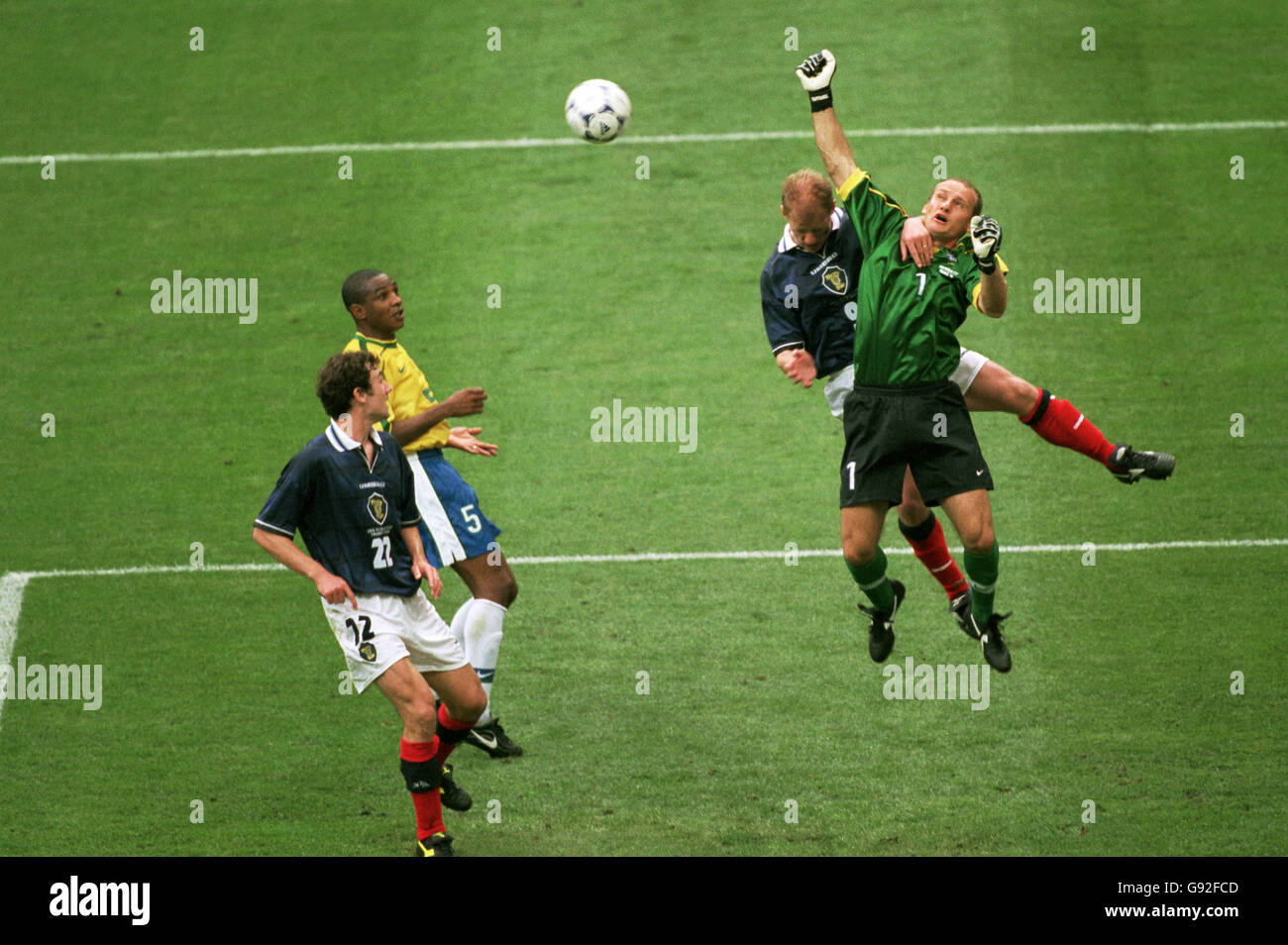 Brazil goalkeeper Taffarel (right) punches clear from Scotland's Gordon Durie (second right) as Brazil's Cesar Sampaio (second left) and Scotland's Christian Dailly (left) look on Stock Photo