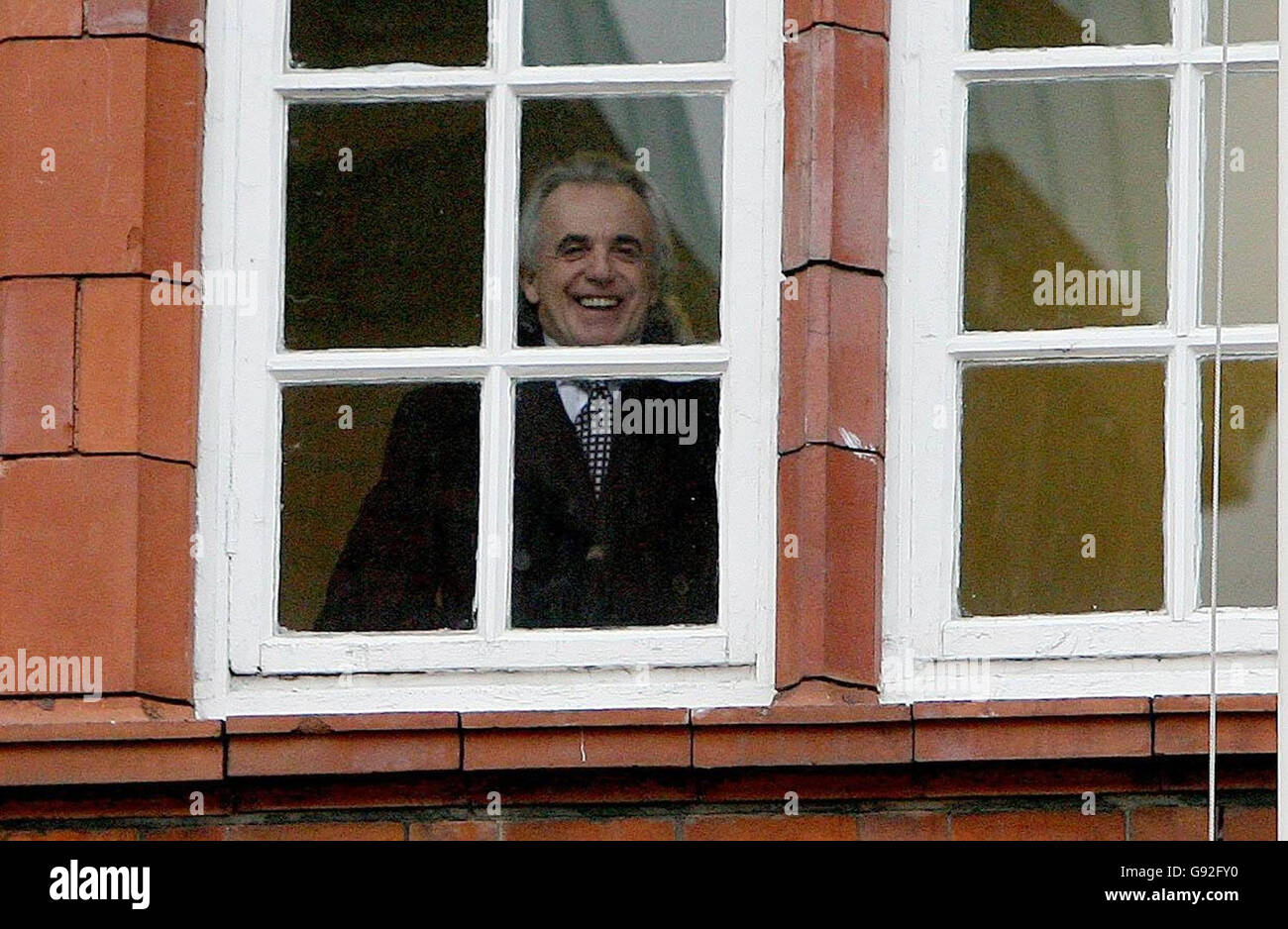 Businessman Peter Stringfellow smiles through a window in Richmond District Court as he awaits the decision on his application to secure a licence for a new lap dancing club in central Dublin, Monday January 9, 2006. The British night club owner is planning to open the club in Parnell Street but he has encountered major opposition from locals who believed it will lower the image and safety of the area. See PA story COURTS Stringfellow. PRESS ASSOCIATION Photo. Photo credit should read: Niall Carson/PA. Stock Photo