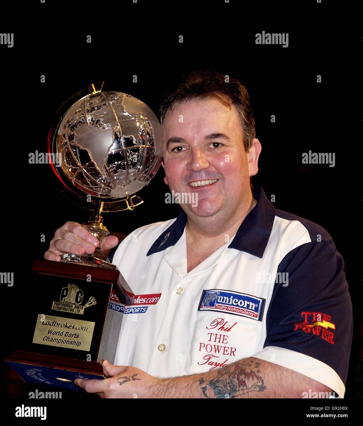England's Phil Taylor holds the World Darts Trophy after winning the final  7-0, against England's