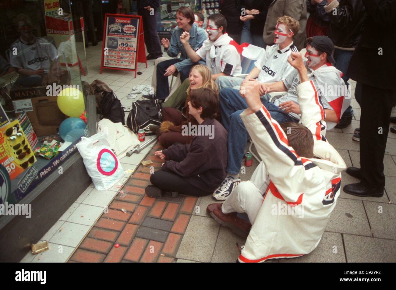 England fans in Nottingham celebrate as they watch the game on a television in a shop window Stock Photo