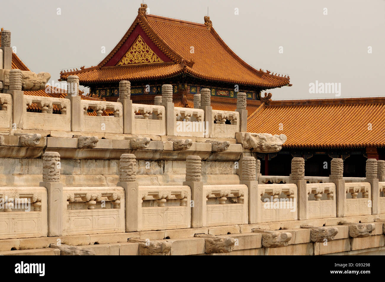 Stone dragon head architectural details on a stone wall and Chinese buildings within the forbidden city in Beijing China on an o Stock Photo