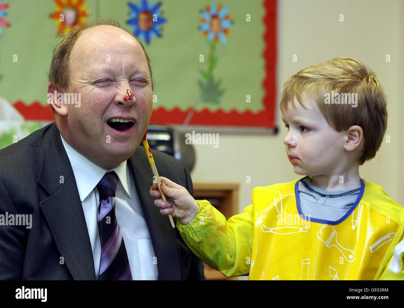 Jim Allister MEP has his face painted at Scribbles Nursery at the Taughmonagh estate in Belfast by three-year-old Joshua Hamilton, Monday January 9, 2006. The nursery, which was founded by the Special European Union Progammes Body (SEUPB), celebrates its first birthday today. PRESS ASSOCIATION Photo. Photo credit should read: Paul Faith / PA. Stock Photo