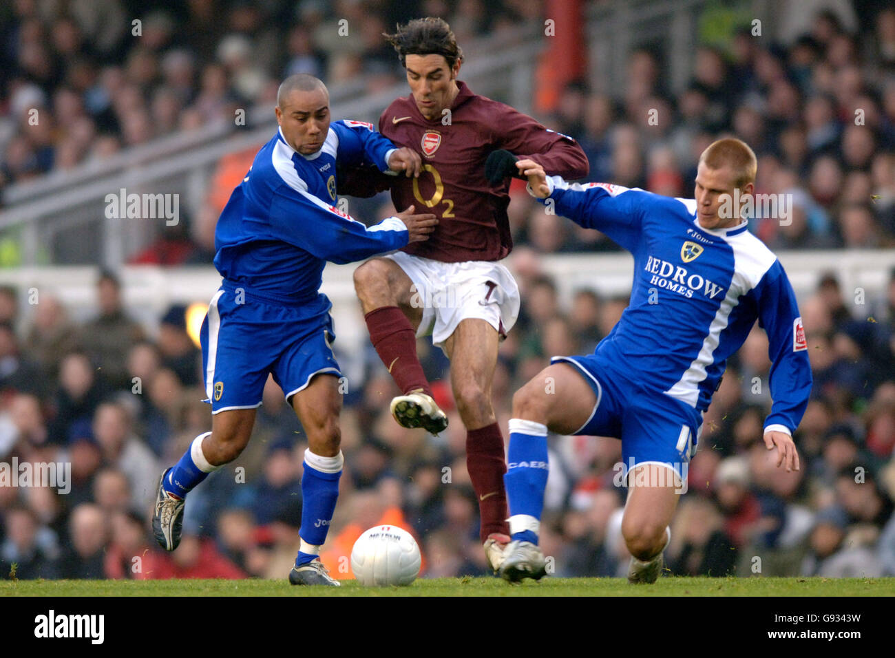 Arsenal's Robert Pires and Cardiff City's Jeff Whitley(l) and Toni Koskela (r) battle for the ball Stock Photo