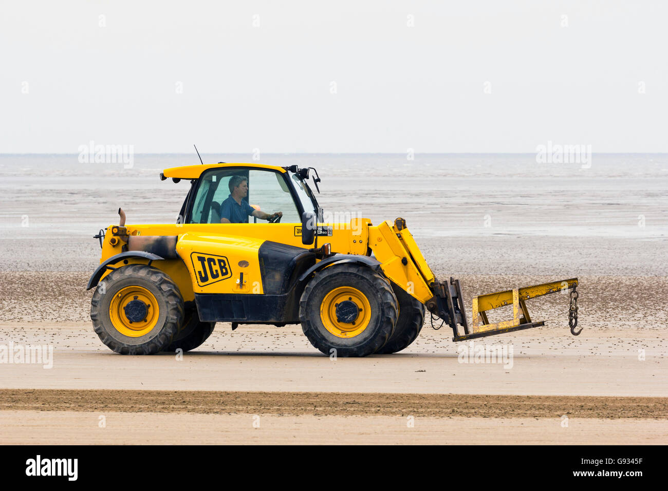 A JCB driving along the beach during the Weston Air Festival, 18th June 2016. Stock Photo