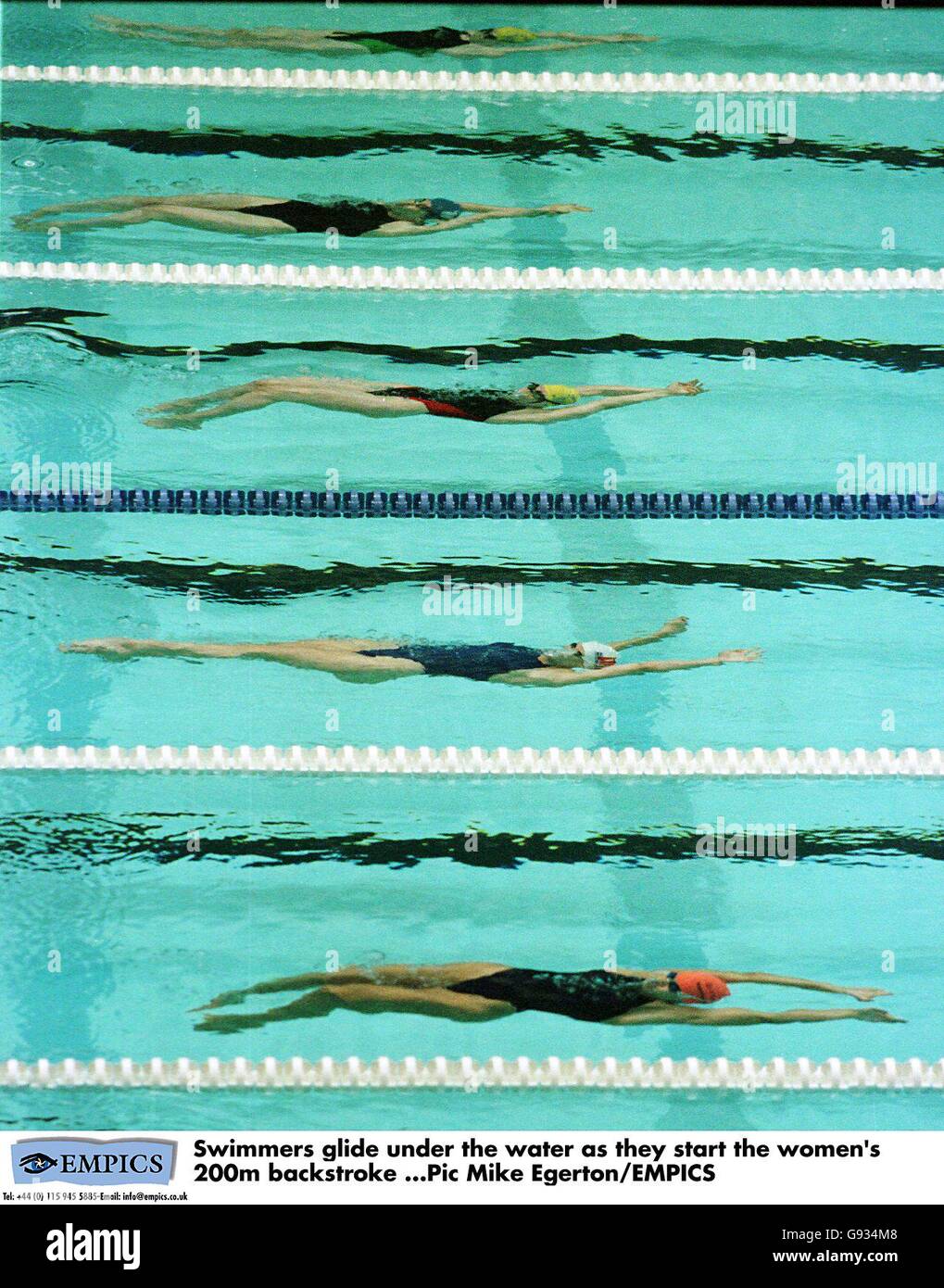 Swimmers glide under the water as they start the women's 200m ...