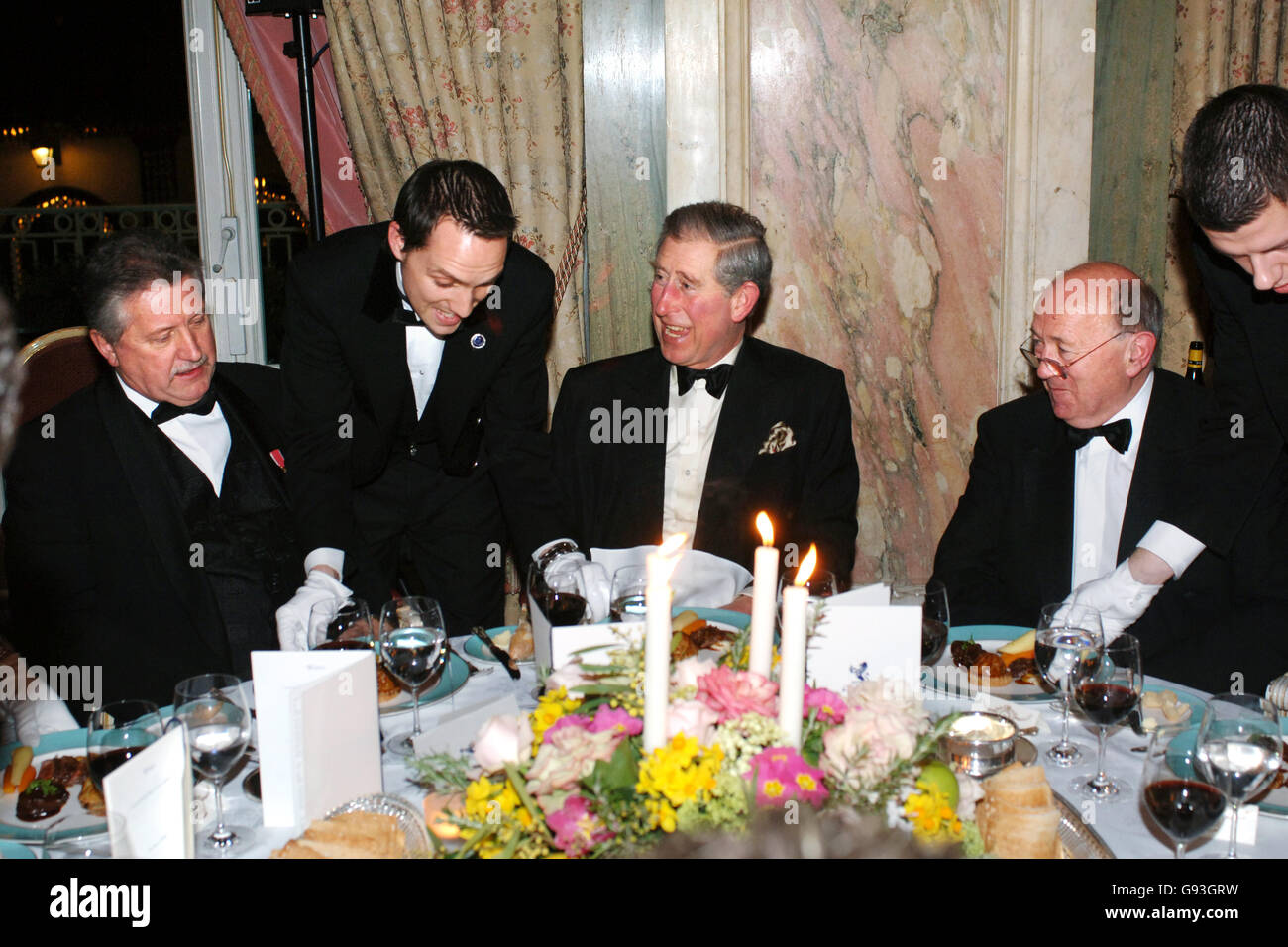 The Prince of Wales (centre) is served with a 'Prince of Wales Trilogy of Mutton' by head waiter Ashley Shaw at the Ritz Hotel, London, Thursday 2 Febuary 2006. The Prince is seated with celebrity chef Brian Turner (left) and Chairman of the National Sheep Association, John Thorley after the Prince officially launched the Mutton Rennaissance Club. See PA story ROYAL Charles. PRESS ASSOCIATION Photo. Photo credit should read: Fiano Hanson/WPA/PA Stock Photo