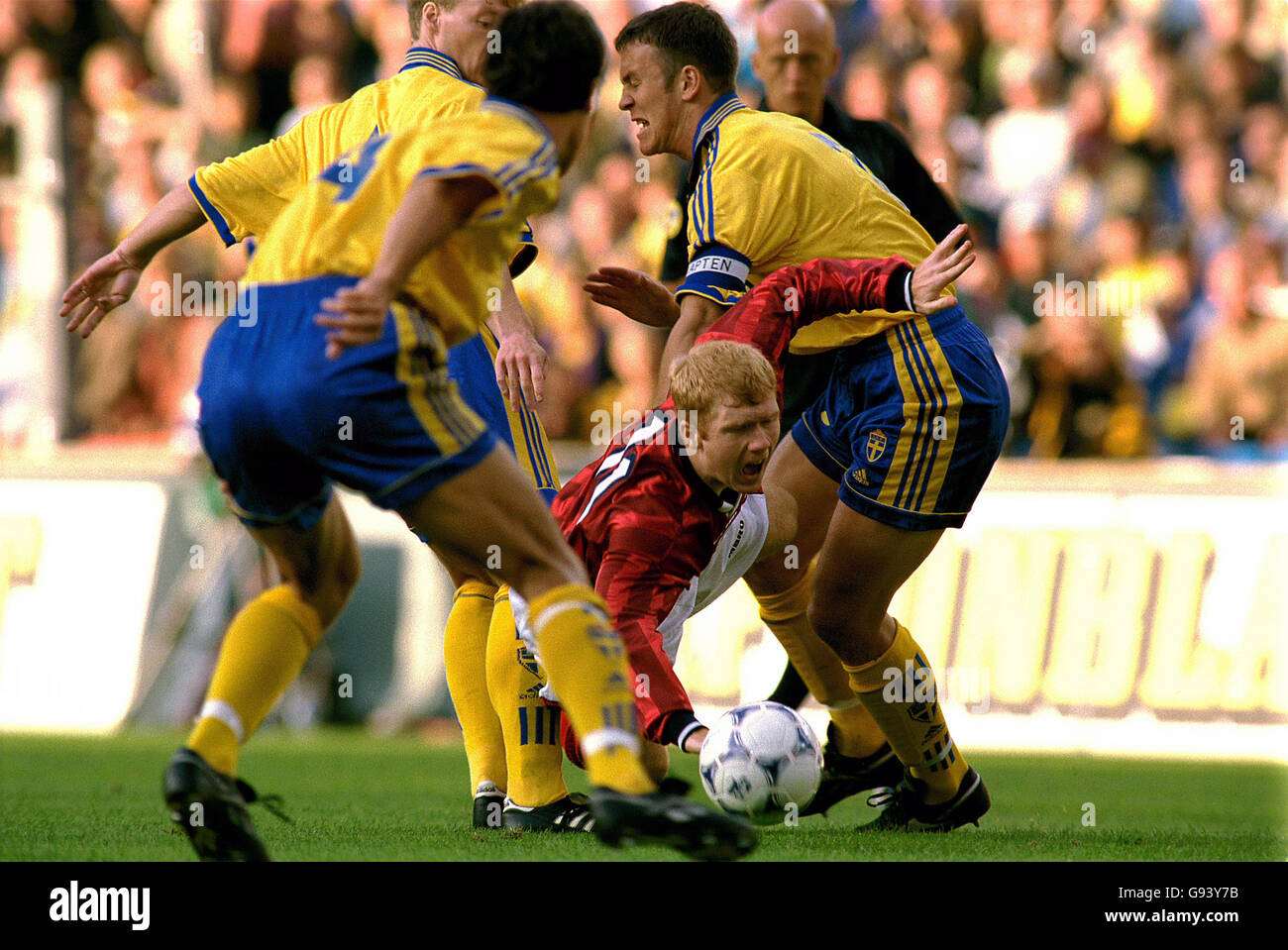 England's Paul Scholes (centre) is brought down by Sweden's Joachim Bjorklund (left) and Patrik Andersson (right) Stock Photo