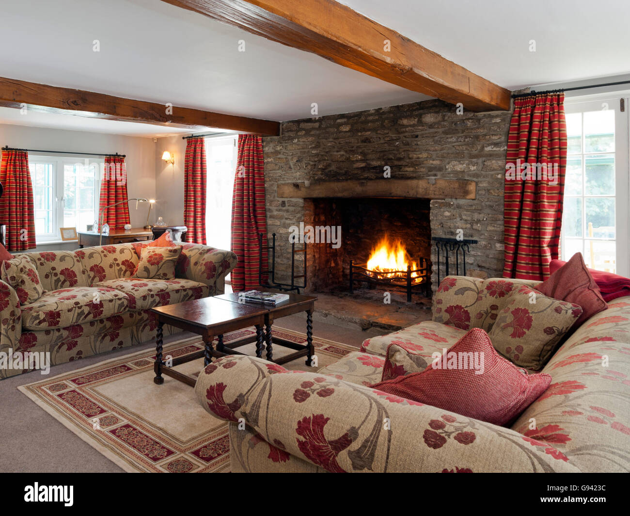 Very traditional sitting room with a roaring open fire Stock Photo