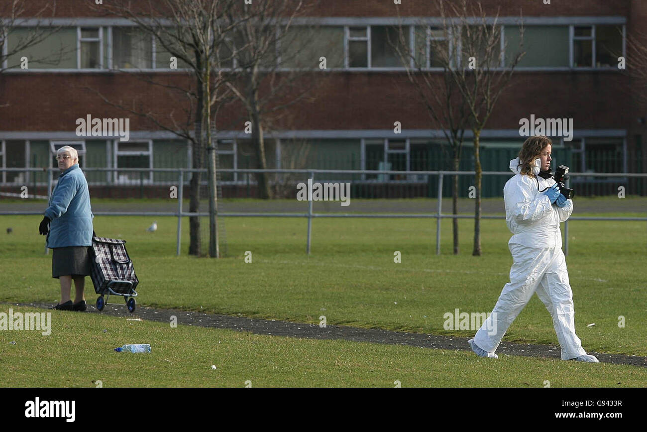 A local resident watches a garda forensic officer photograph the scene
