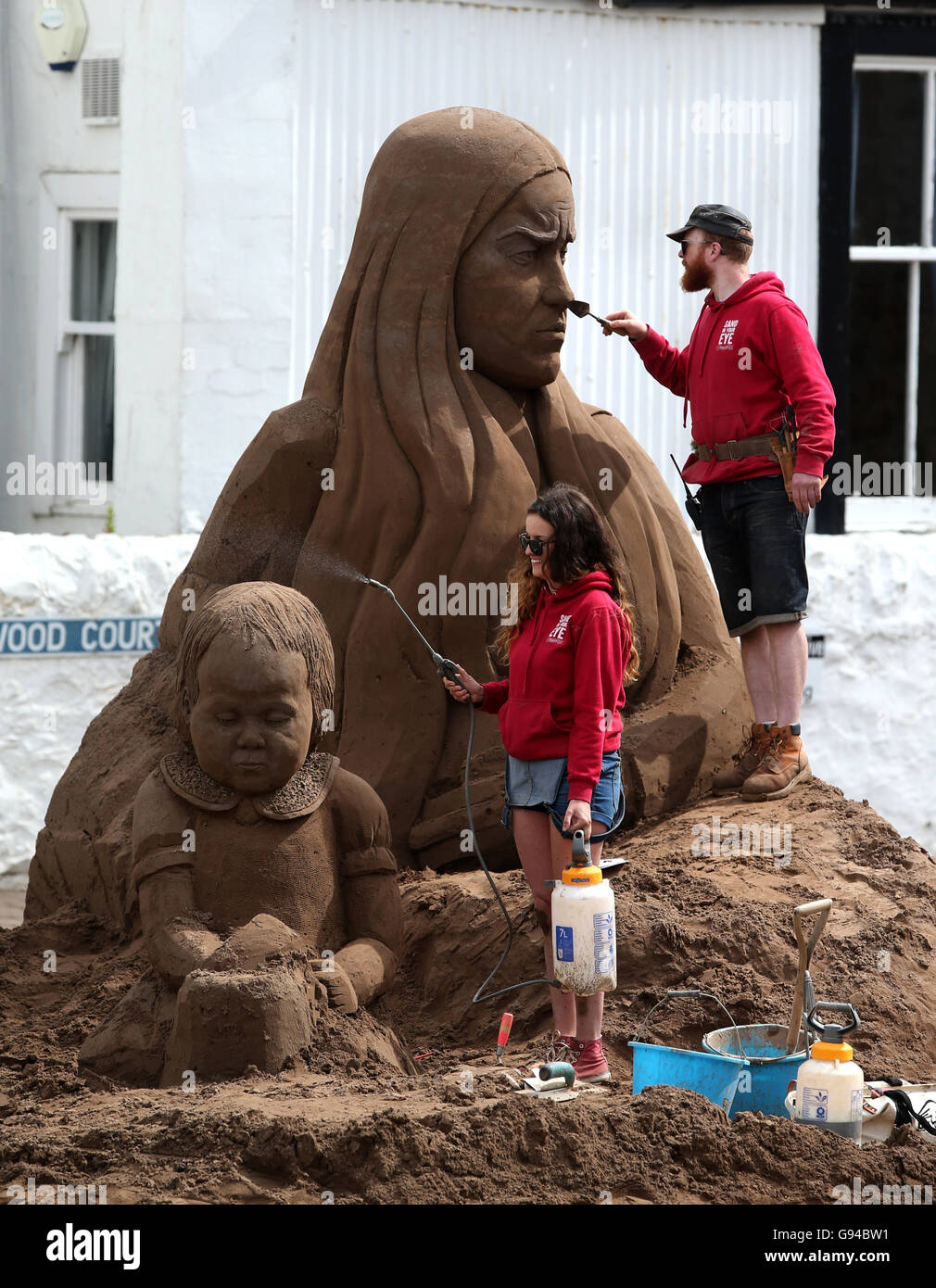 Artists Claire Jamieson and Jamie Wardley put the finishing touches to a  life size sand sculpture titled "Those Left Behind" by the Sand In Your Eye  team, as a commemorative event takes