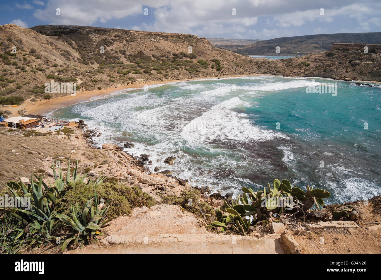 The sandy beach below the rocky cliffs of the Malta island Stock Photo