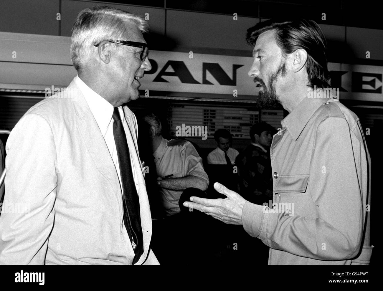 With his western-style hat, long hair and beard, actor Laurence Harvey (right) speaks with actor Cary Grant. Stock Photo