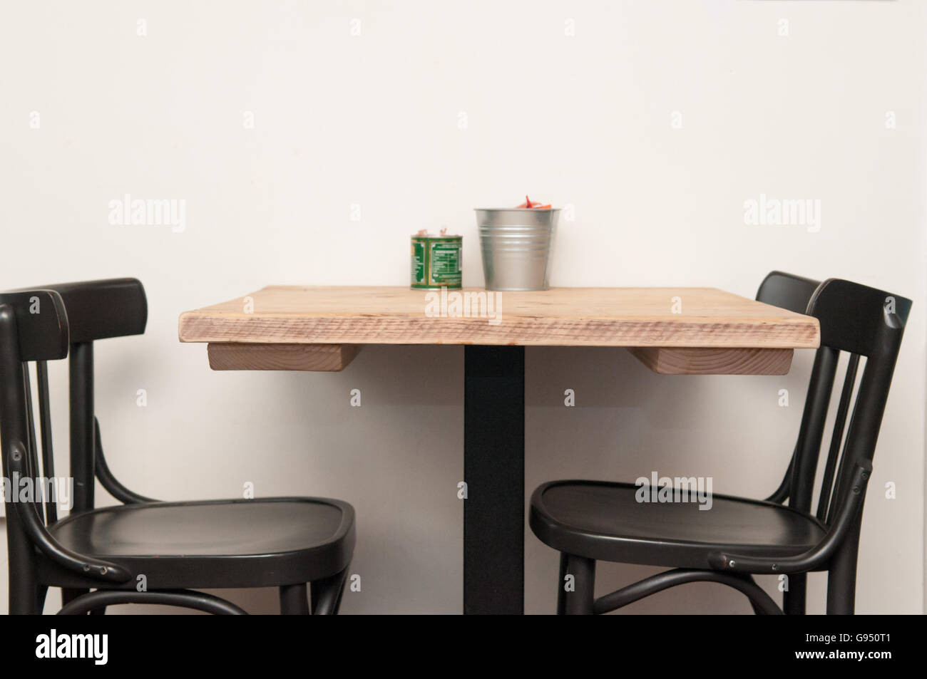 Wooden table with two chairs and a white wall background Stock Photo ...