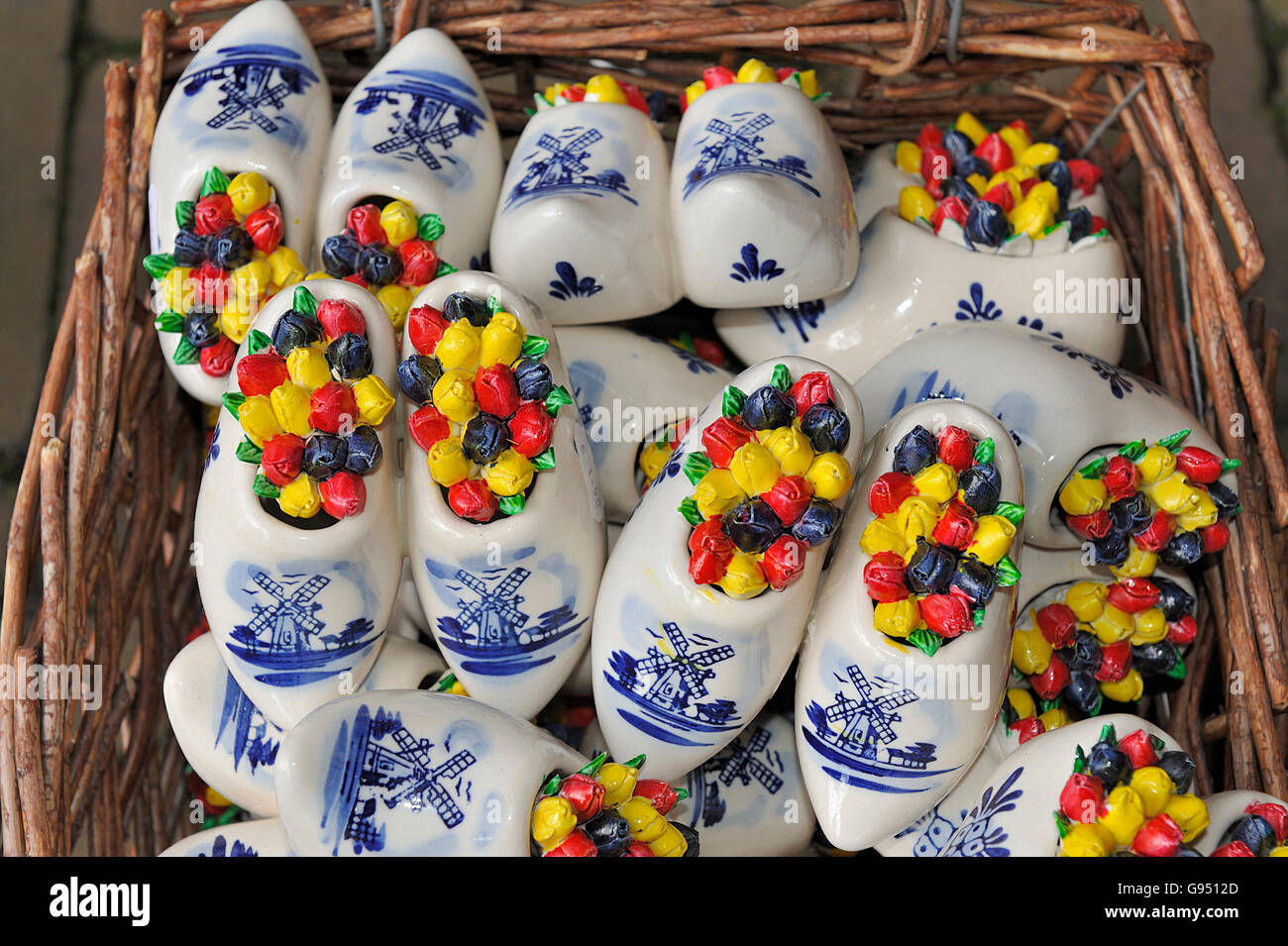 Mini ceramic Delft Blue wooden shoes with windmill decoration and colored Dutch tulips Stock Photo