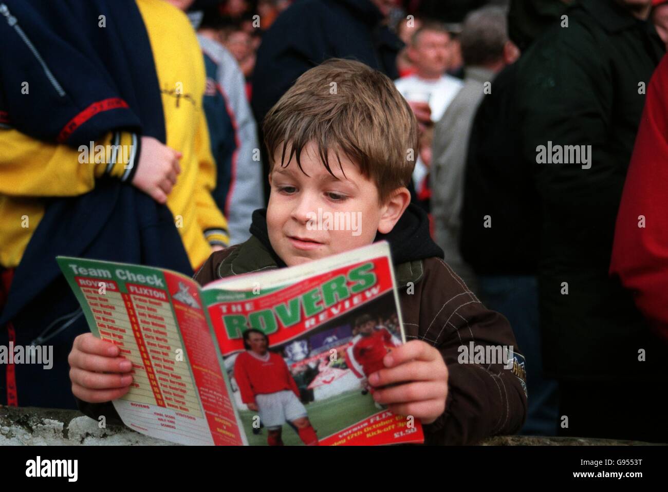 A young Doncaster Rovers fan reading the match programme Stock Photo ...