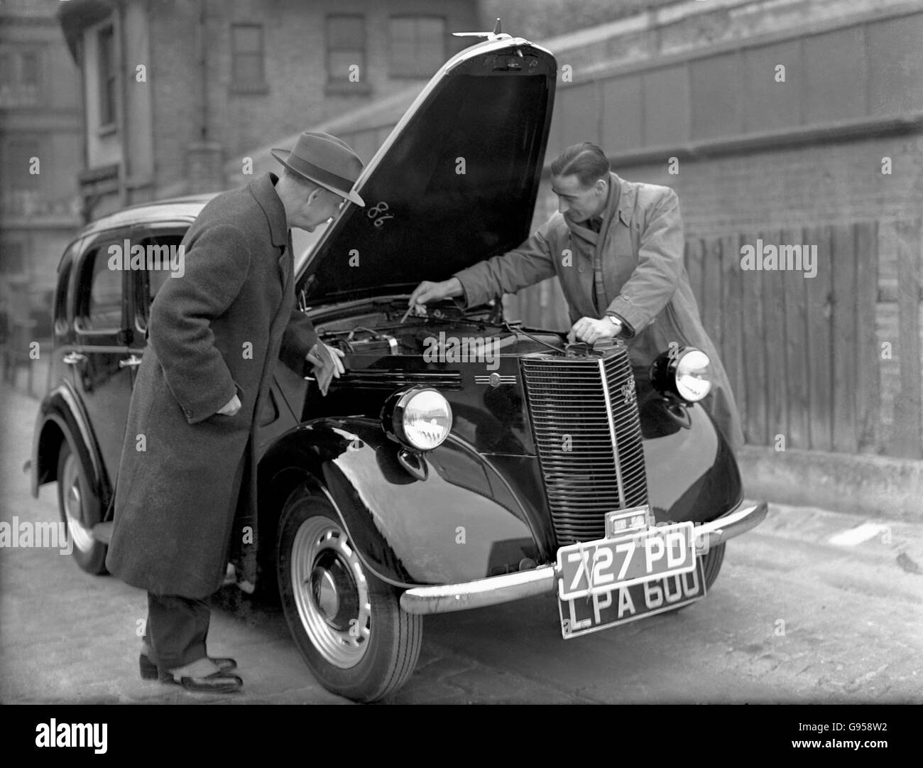 Soccer - Chelsea's Tommy Walker Buys a New Car. Chelsea's Tommy Walker (r) points out an interesting feature in the engine of his new car to AE Ford (l), Middlesex Wanderers RFU President Stock Photo
