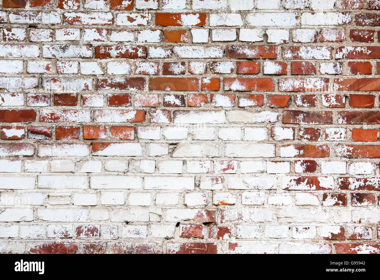 vintage red brick wall painted white with peeling off paint Stock Photo