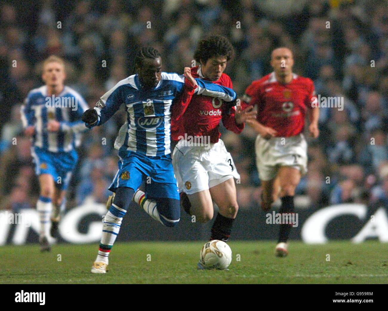 (L-R) Wigan Athletiic's Pascal Chimbonda and Manchester United's Ji-Sung Park battle for the ball Stock Photo