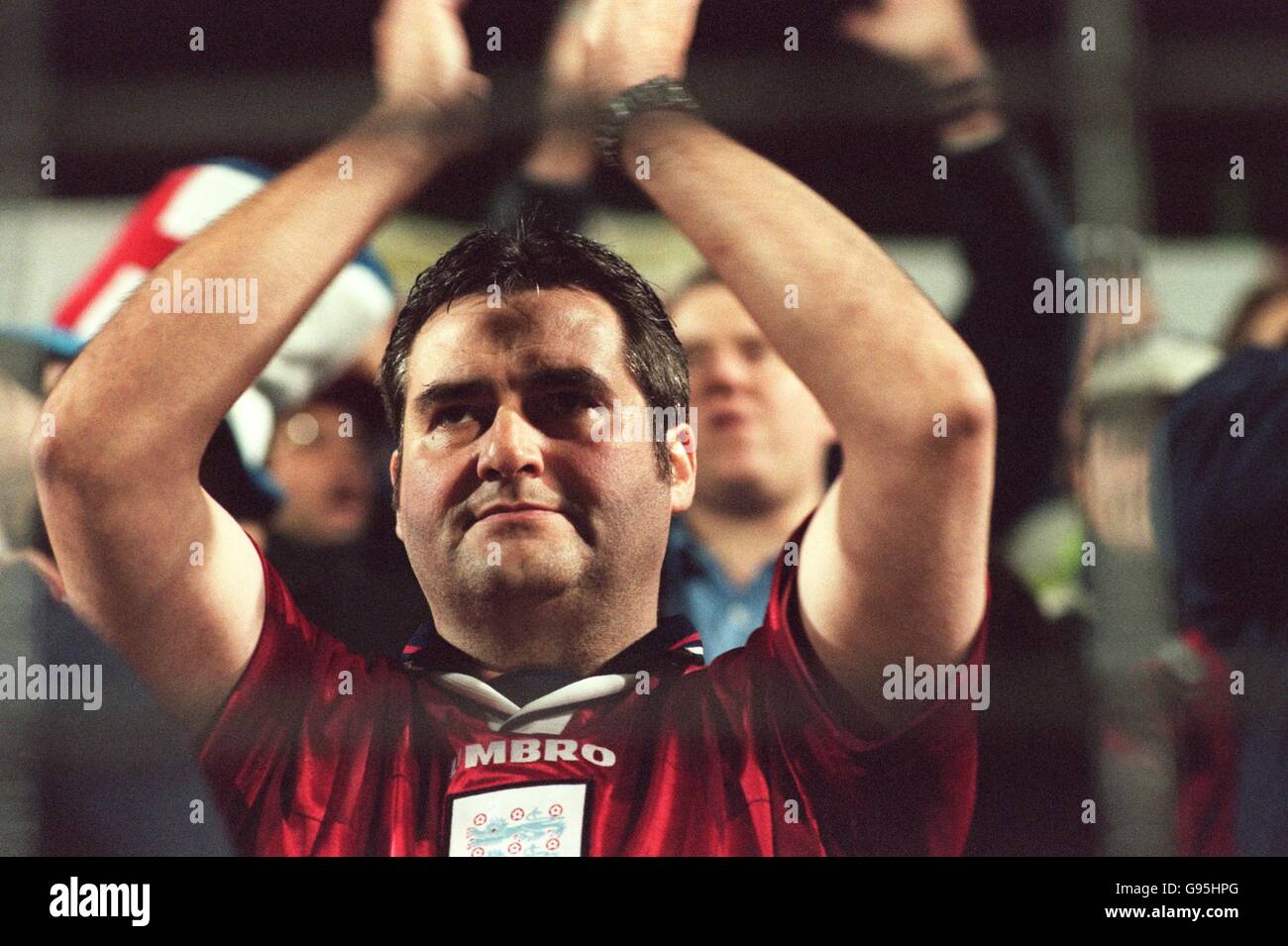 An England fan applauds the singing of the national anthem Stock Photo