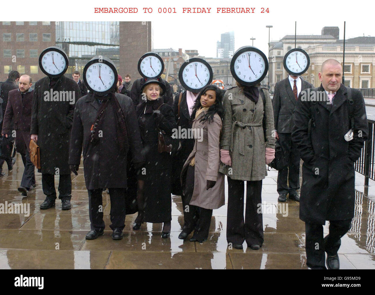 The Trade Union Congress (TUC) organise a stunt portraying commuters, some of whom are wearing clock-faces as masks with the time set at 5pm, walking across London Bridge in London, Thursday February 23, 2006. The stunt comes ahead of tomorrow's 'Work Your Proper Hours Day' when workers are being encouraged to arrive at work on time, take a proper lunch break and leave when they are meant to. PRESS ASSOCIATION Photo. Photo credit should read: Johnny Green/PA. Stock Photo