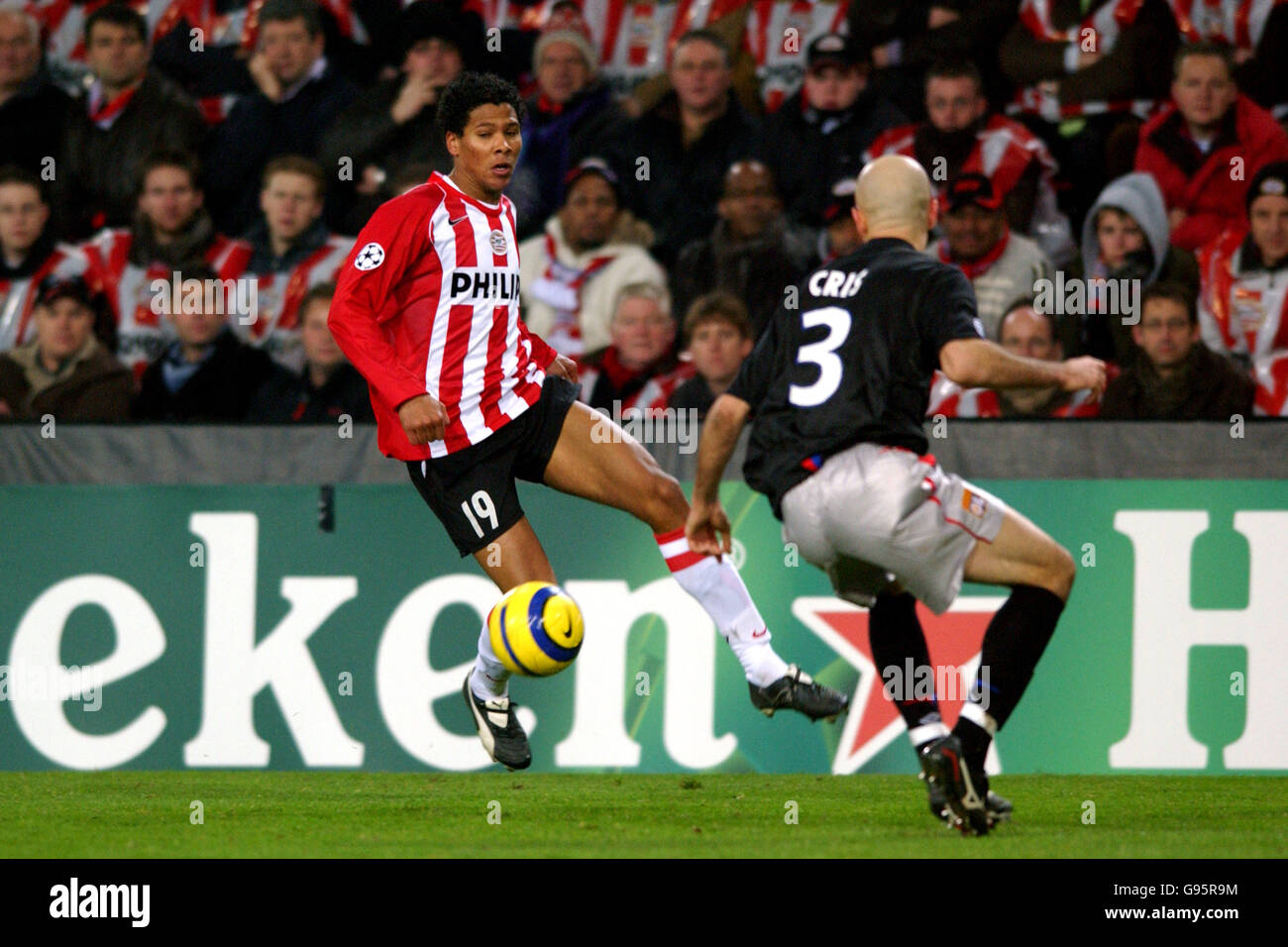 Soccer - UEFA Champions League - Round of 16 - First Leg - PSV Eindhoven v Olympique Lyonnais - Philips Stadium. PSV Eindhoven's Michael Lamey and Olympique Lyonnais' Cris battle for the ball Stock Photo