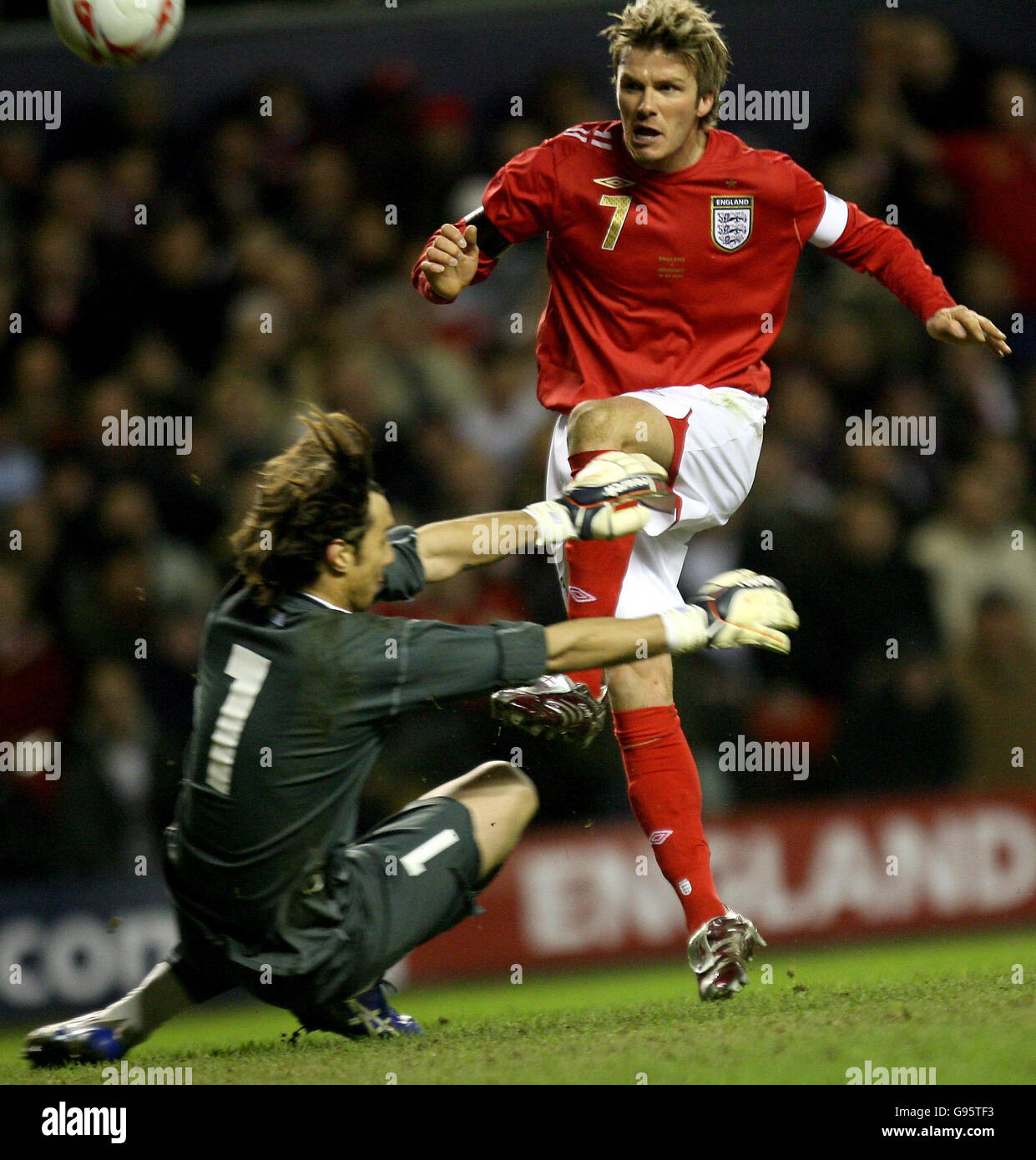 England's David Beckham (R) tries to chip past Uruguay's goalkeeper Fabian Carini during the friendly International match at Anfield, Liverpool, Wednesday March 1, 2006. PRESS ASSOCIATION Photo. Photo credit should read: Owen Humphreys/PA. Stock Photo